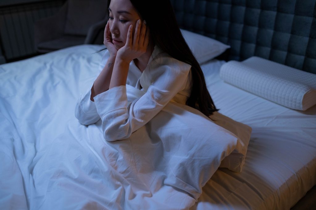 woman sitting in bed with insomnia